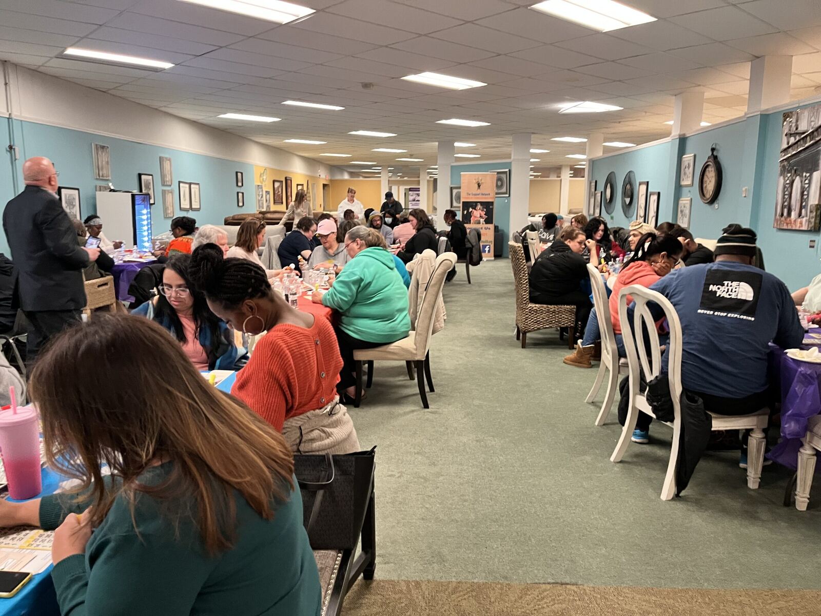 A full room of parents and community members seated at tables during an event