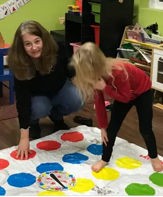 An adult and a child playing Twister together